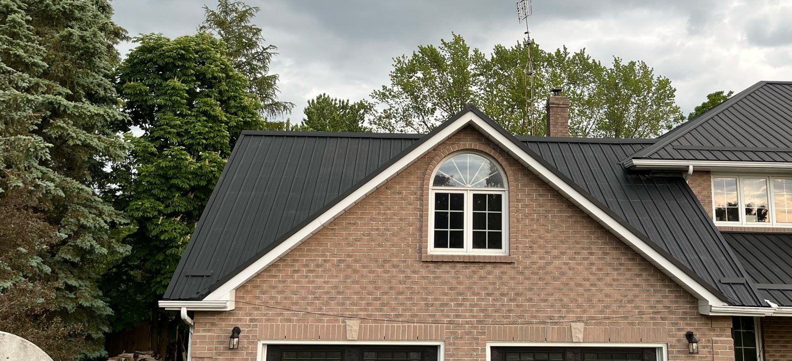 Steel roof over a brick home with gable dormer