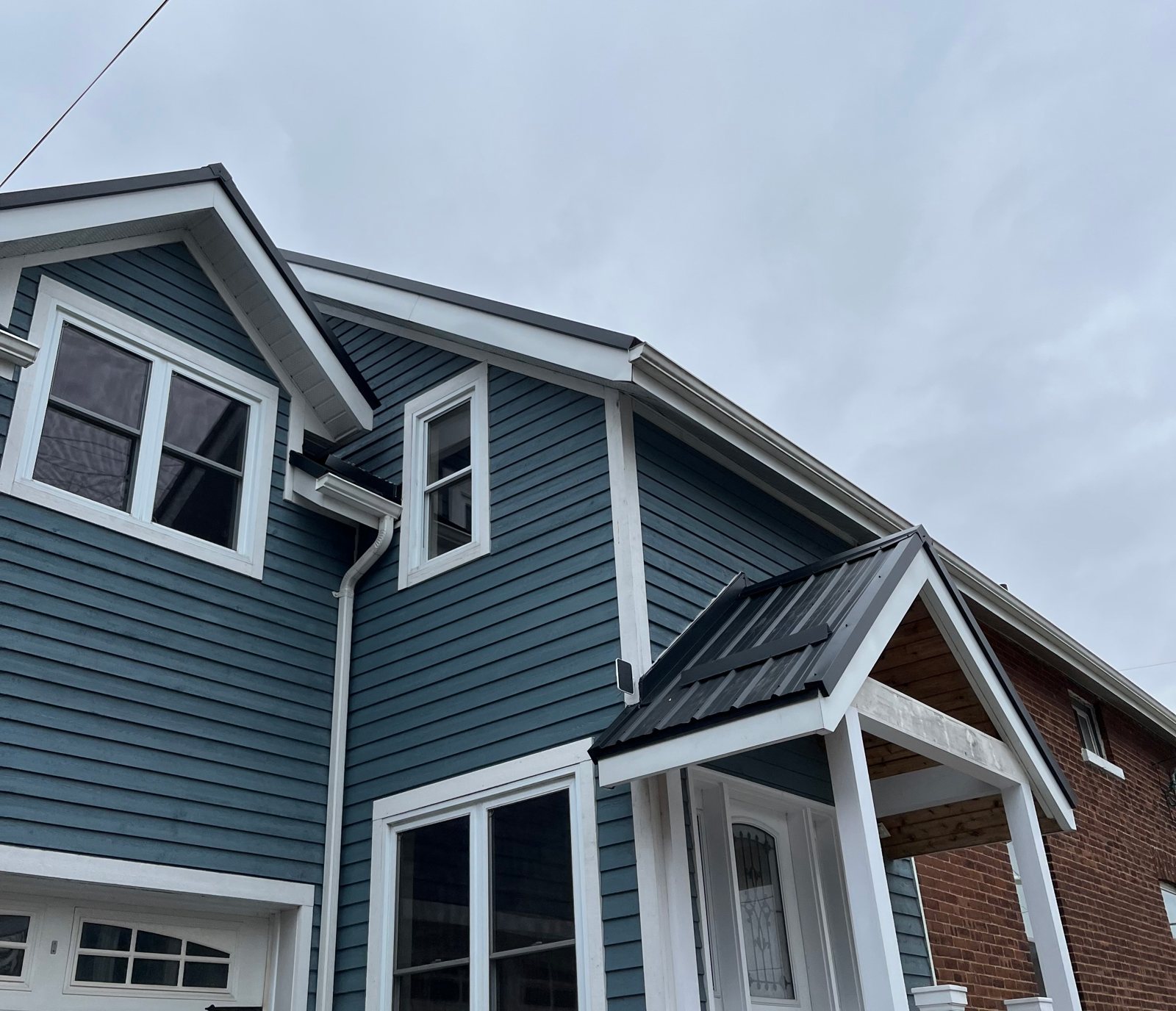 Blue-grey home with steel roof and dormers