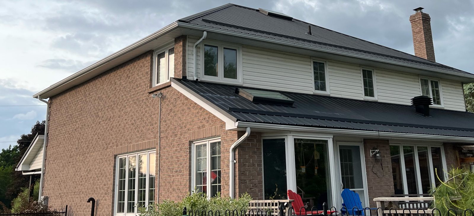 Two-storey brick home with charcoal metal roof