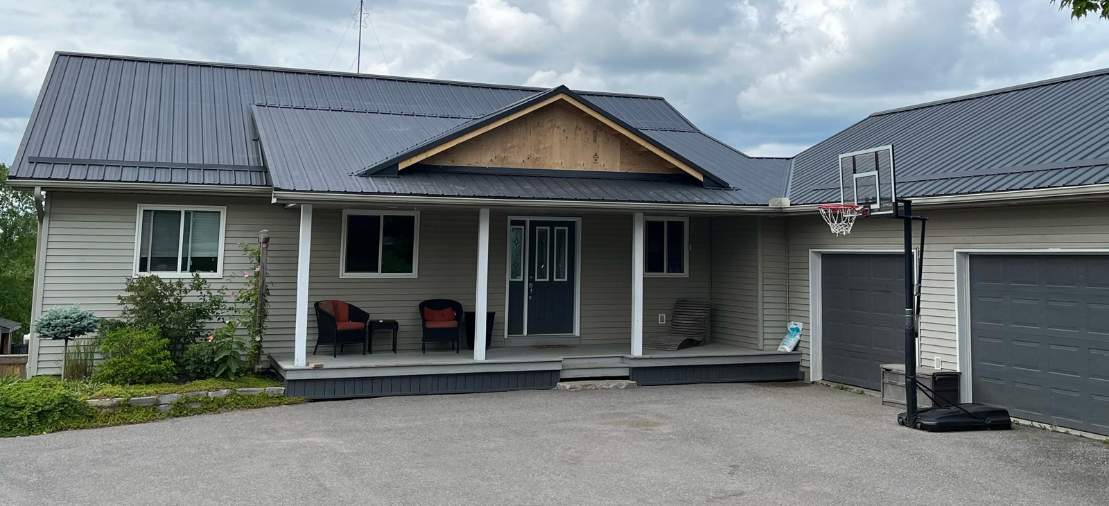 Grey standing seam roof on a bungalow with attached garage