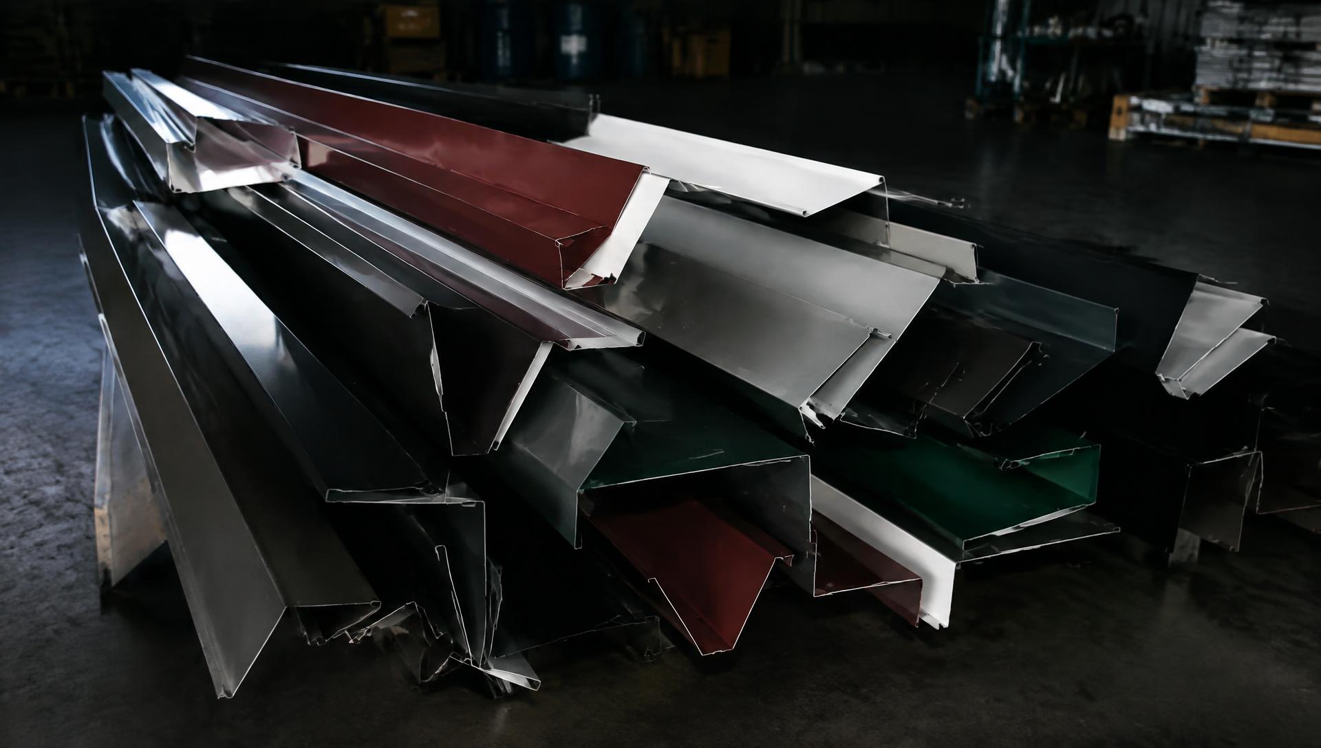 Bent steel trim and flashing stacked on the shop floor